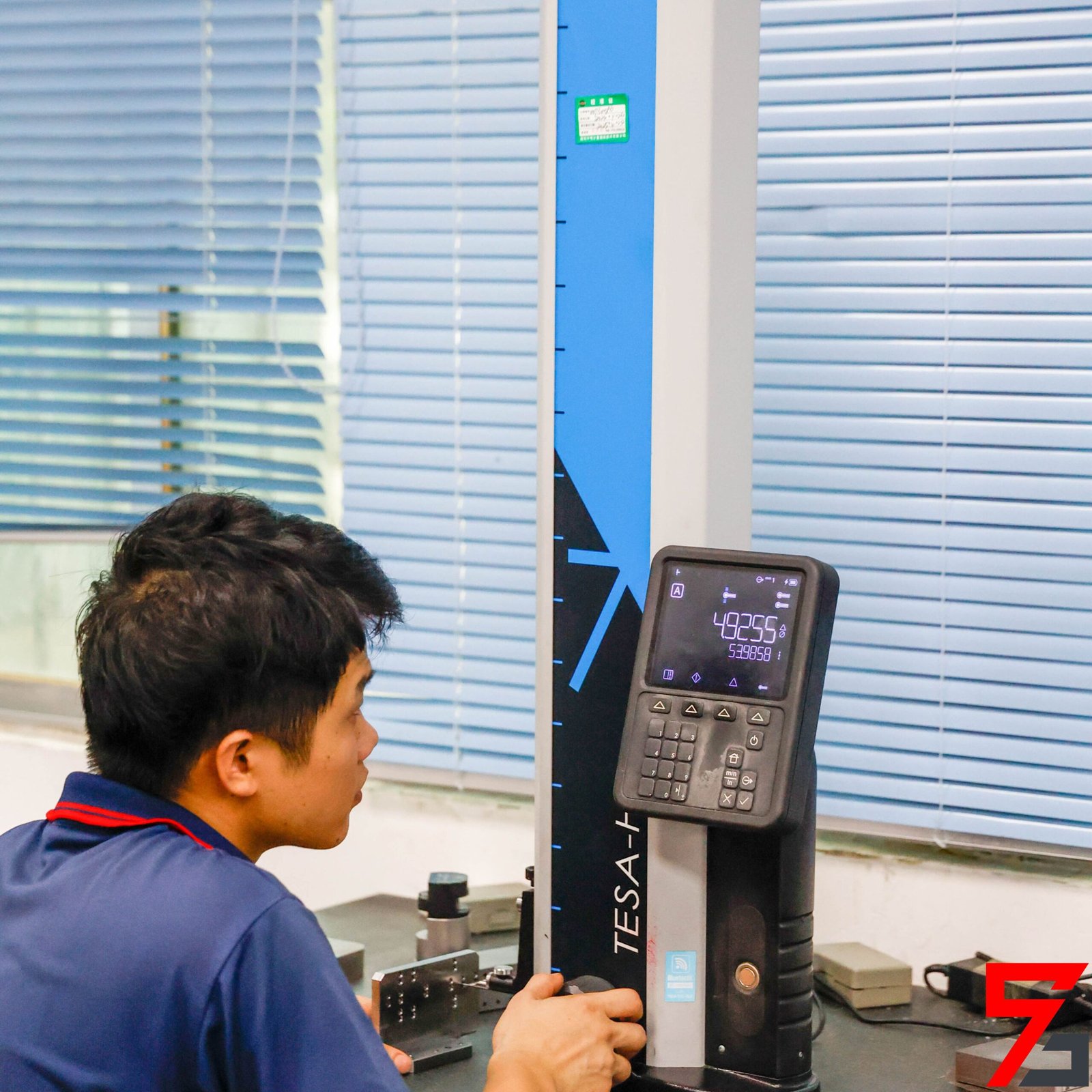 The quality inspector is operating the height gauge